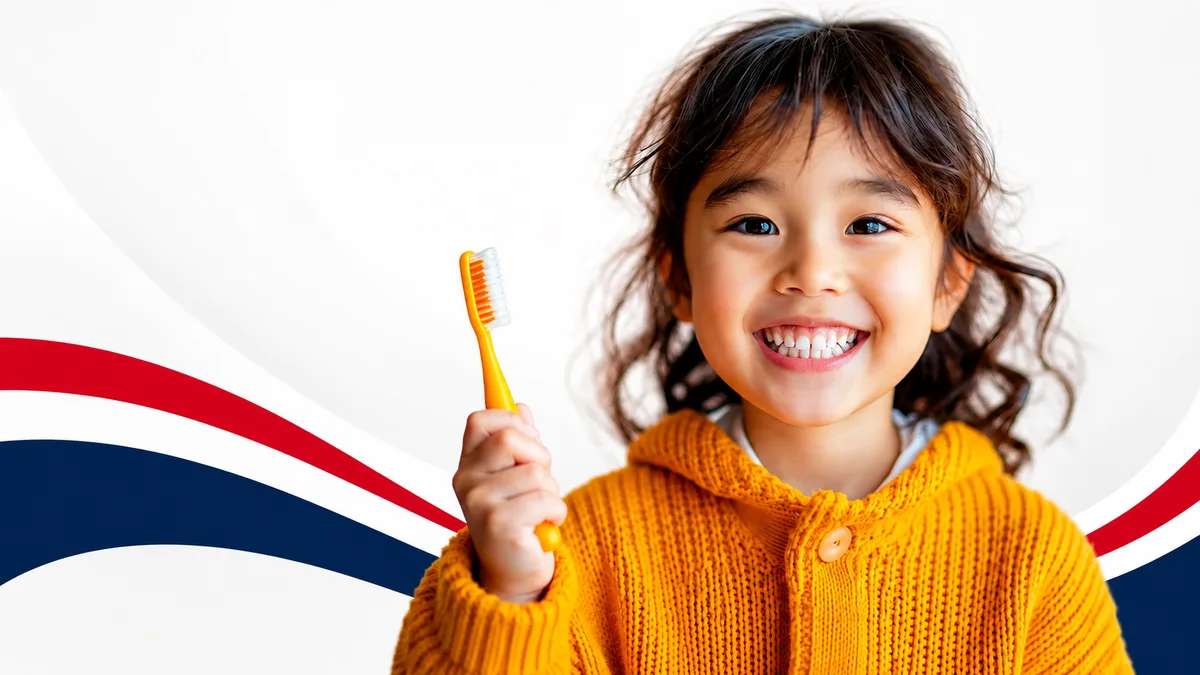 A smiling child holding a toothbrush at Tomorrow’s Dentistry